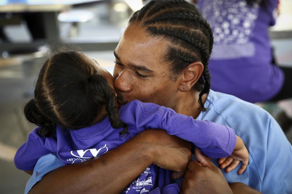 Pharaoh Haywood holds his daughter during a "Get On the Bus" visiting day to Folsom State Prison