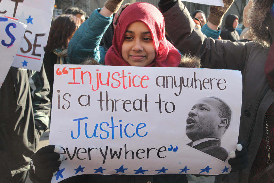 A Muslim girl holds a sign with a quote from Martin Luther King Jr. during a protest outside of the U.S. Consulate in downtown Toronto, Ontario, Canada, on Jan. 30, 2017.