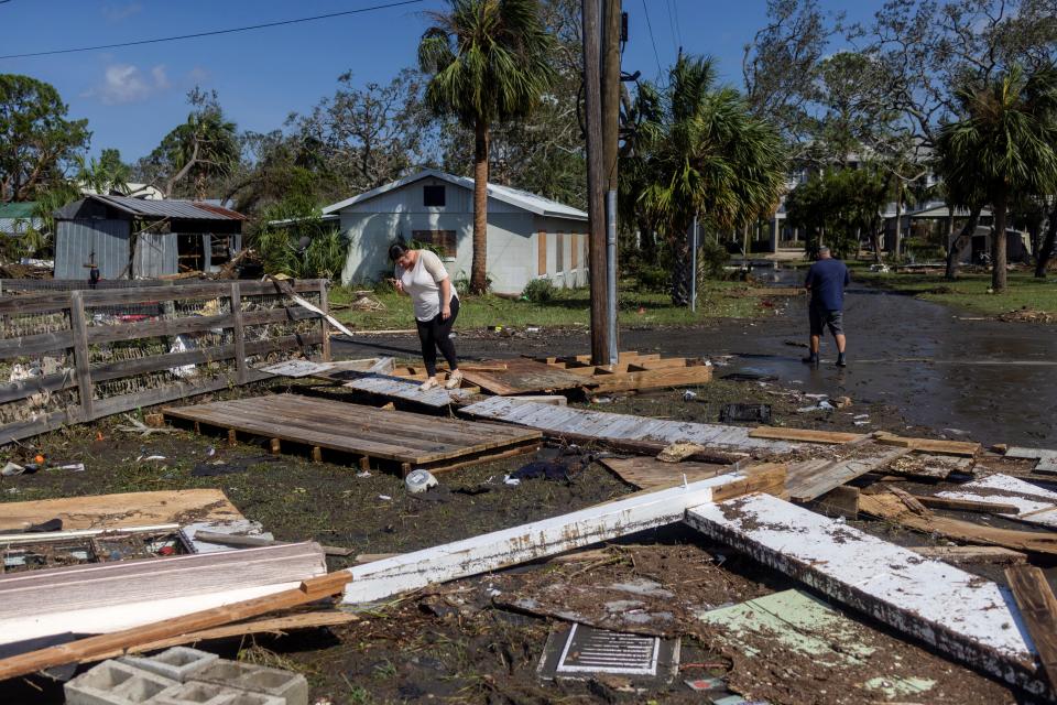 Elizabeth Kight inspects the damage on a street filled with debris from Hurricane Helene in Horseshoe Beach, Florida, U.S., on Sept. 27, 2024.