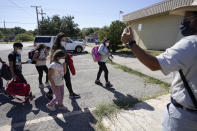 A member of a humanitarian group, right, greets migrants after they were released from U.S. Customs and Border Protection custody, Friday, Sept. 24, 2021, in Del Rio, Texas. (AP Photo/Julio Cortez)