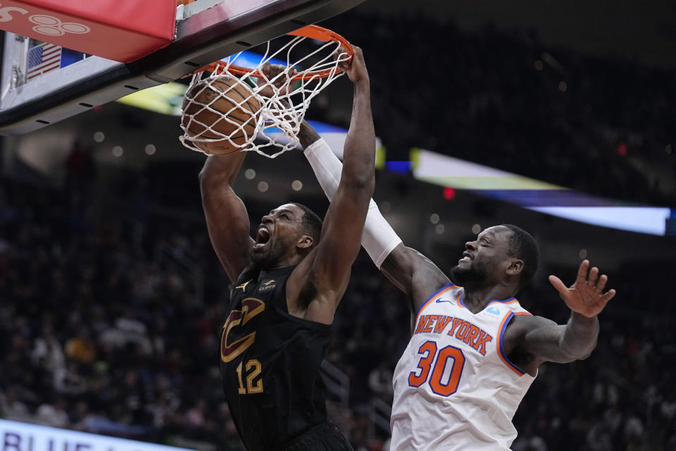 Cleveland Cavaliers center Tristan Thompson (12) dunks in front of New York Knicks forward Julius Randle (30) during the first half of an NBA basketball game Tuesday, Oct. 31, 2023, in Cleveland. (AP Photo/Sue Ogrocki)