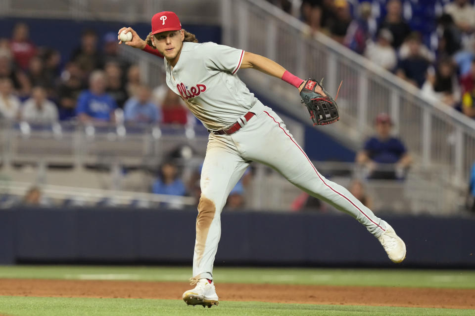 Philadelphia Phillies first baseman Alec Bohm throws to first base but is late with the out against Miami Marlins shortstop Jon Berti during the ninth inning of a baseball game, Tuesday, Aug. 1, 2023, in Miami. (AP Photo/Marta Lavandier)