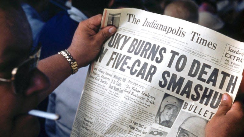 A spectator reads a copy of the The Indianapolis Times 'Speedway Extra', 4th Edition, reporting the death of driver Bill Vukovich with the headline: 