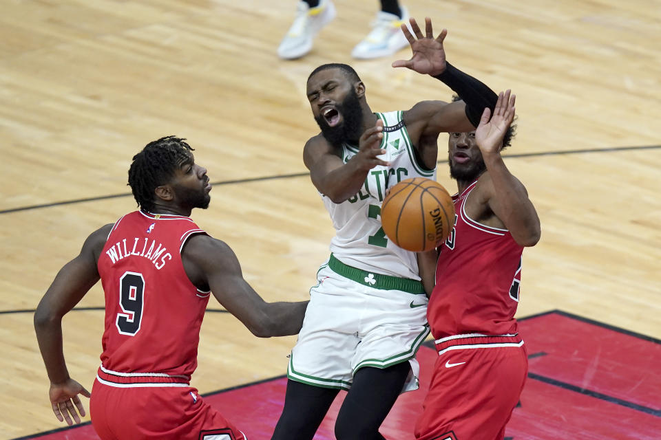 Boston Celtics' Jaylen Brown (7) loses control of the ball off the defense of Chicago Bulls' Thaddeus Young as Patrick Williams watches during the first half of an NBA basketball game Monday, Jan. 25, 2021, in Chicago. (AP Photo/Charles Rex Arbogast)