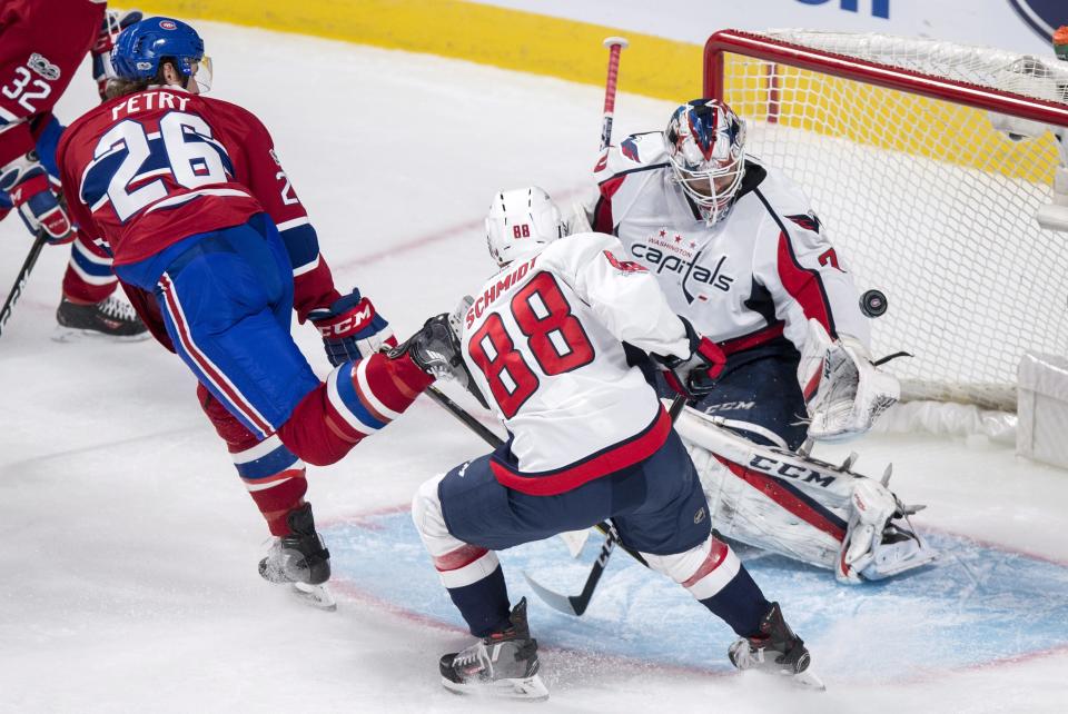 Washington Capitals goalie Braden Holtby (70) stops a shot by Montreal Canadiens defenseman Jeff Petry (26) as defenseman Nate Schmidt (88) watches during the second period of an NHL hockey game Monday, Jan. 9, 2017, in Montreal. (Paul Chiasson/The Canadian Press via AP)