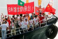 Activists shout slogans and wave the Chinese flag aboard a vessel in Hong Kong, October 22, 2006. Japan and China have sparred over a group of uninhabited islands known as the Senkaku Islands to Japanese and the Diaoyu Islands in China. The area is believed to lie near oil and gas reserves. In October 2006, a boat carrying activists from the Hong Kong-based Action Committee for Defending the Diaoyu Islands sailed within 20 km of the main island in the chain before they were warned off by a Japanese patrol boat. Chinese writing on a banner reads: "Japan get out of the Diaoyu Islands". REUTERS/Paul Yeung/File photo