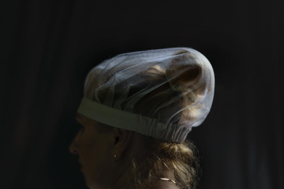 The hair bun of Svitlana Labutcheva, is tied up and covered in a hair net as she works at a bakery in Kostiantynivka, Donetsk region, eastern Ukraine, Saturday, Aug. 20, 2022. The factory bakes about 7 tons of bread daily, or about 17,500 loaves. Half of it goes to the Ukrainian military. (AP Photo/David Goldman)