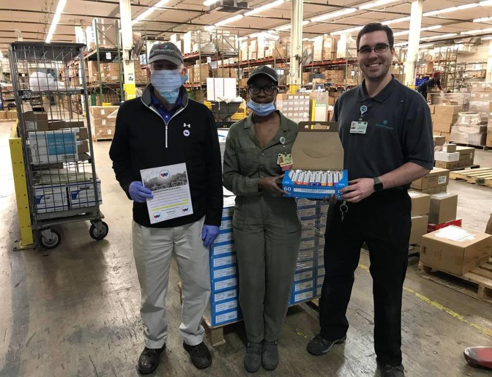 Workers at Atrium Health’s distribution center in Charlotte’s NoDa section pose with some of the 20,040 bars of chocolate delivered there on Friday morning, April 10, 2020.