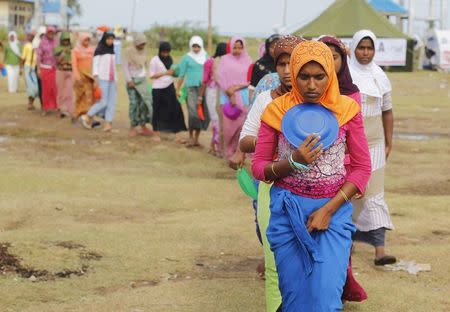 Rohingya migrant women, who arrived in Indonesia by boat, hold plates as they queue up for breakfast inside a temporary compound for refugees in Kuala Cangkoi village in Lhoksukon, Indonesia's Aceh Province May 17, 2015. REUTERS/Beawiharta