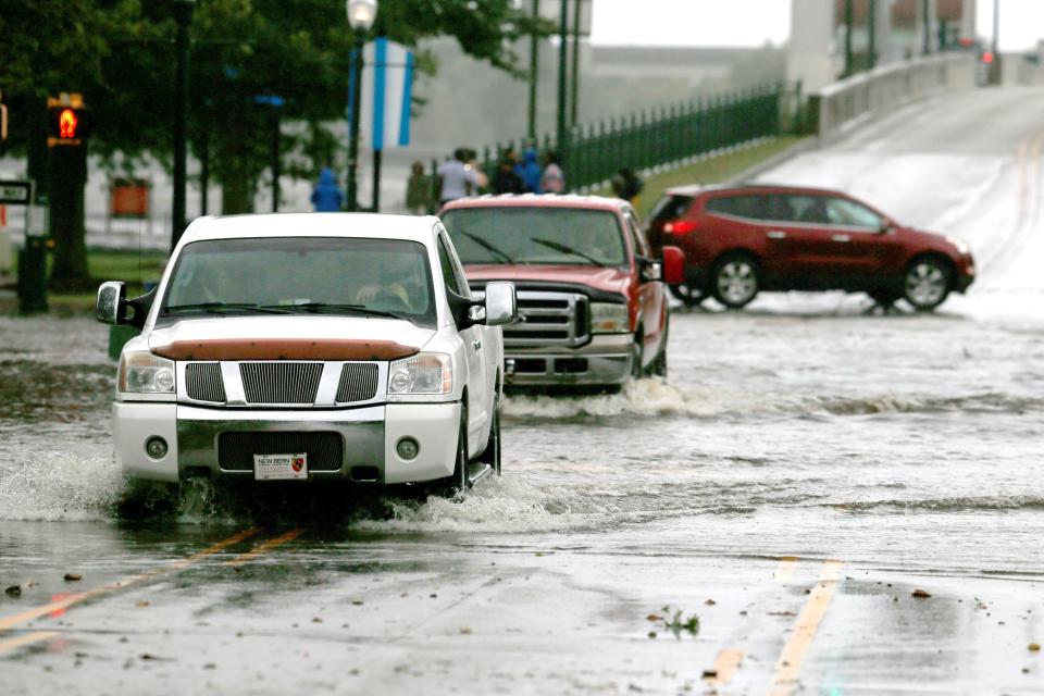 Cars go through a flooded street during the heavy rain of outer bands of Hurricane Florence in New Bern on Thursday.