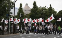 Member of the nationalist movement "Ganbare Nippon" holding Japanese national flags walk in front of the parliament during a rally in Tokyo September 11, 2013, on the day of one year anniversary of Japanese government signed contract to buy islands disputed with China from a private owner. China said it would not tolerate provocation after Japan's top government spokesman said on Tuesday Japan might station government workers on disputed islands in the East China Sea to defend its sovereignty. Relations between the world's second- and third-biggest economies have been strained over the uninhabited isles which Japan controls but both countries claim. (REUTERS/Toru Hanai)