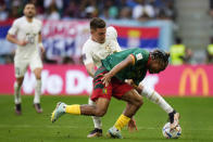 Serbia's Sergej Milinkovic-Savic, left, and Cameroon's Pierre Kunde battle for the ball during the World Cup group G soccer match between Cameroon and Serbia, at the Al Janoub Stadium in Al Wakrah, Qatar, Monday, Nov. 28, 2022. (AP Photo/Manu Fernandez)