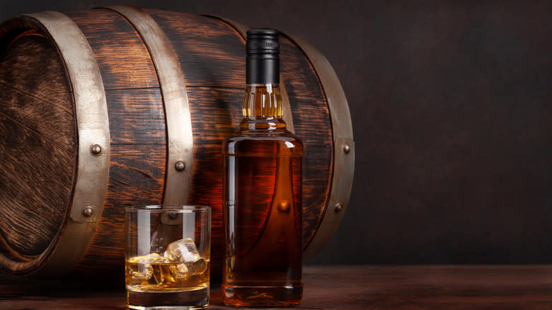Bourbon barrel with whiskey bottle