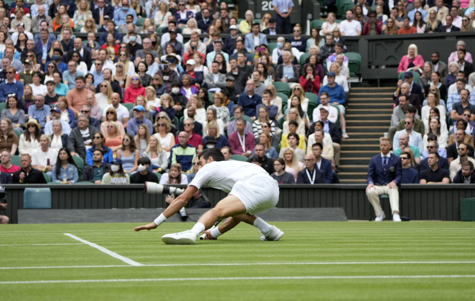 Novak Djokovic se resbala durante el partido contra Kevin Anderson por la segunda ronda del torneo de Wimbledon, el miércoles 30 de junio de 2021. (AP Foto/Alastair Grant)