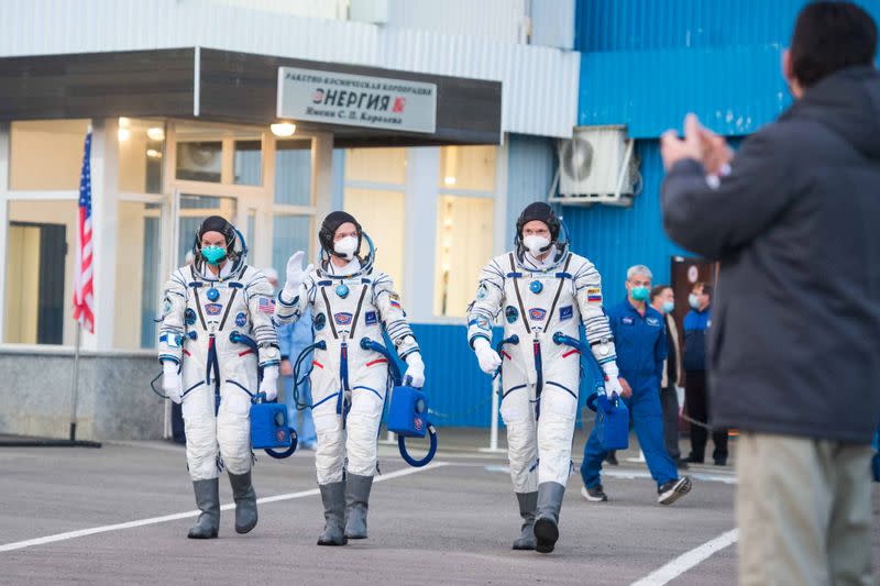 The International Space Station (ISS) crew members walk to depart to the launchpad at the Baikonur Cosmodrome