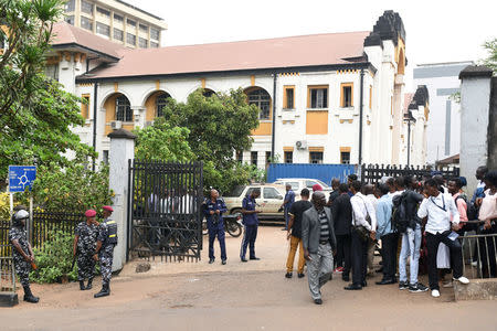 Police officers and people stand outside the high court in Freetown, Sierra Leone March 26, 2018. REUTERS/Olivia Acland