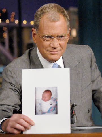 <p>John Paul Filo/CBS/Getty</p> David Letterman holds a photo of his new son, Harry Joseph Letterman during 'Late Show with David Letterman' on Nov. 4, 2003