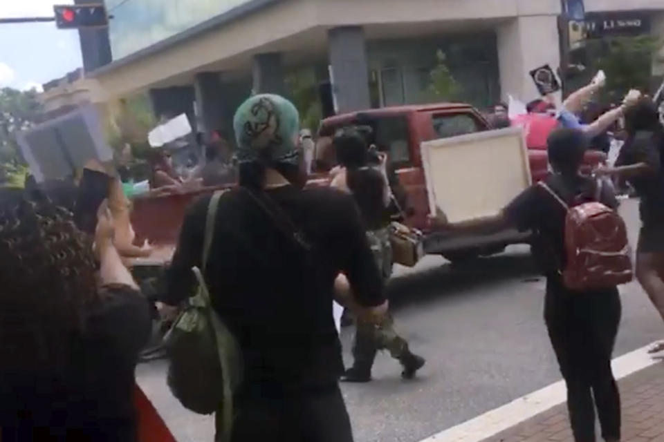 In this image taken from from video provided by @alexisnscott._, a pickup truck drives through a crowd of protesters, Saturday, May 30, 2020, in Tallahassee, Fla Tallahassee police said Saturday that the driver was in custody and that no one was seriously injured. (@alexisnscott._ via AP)