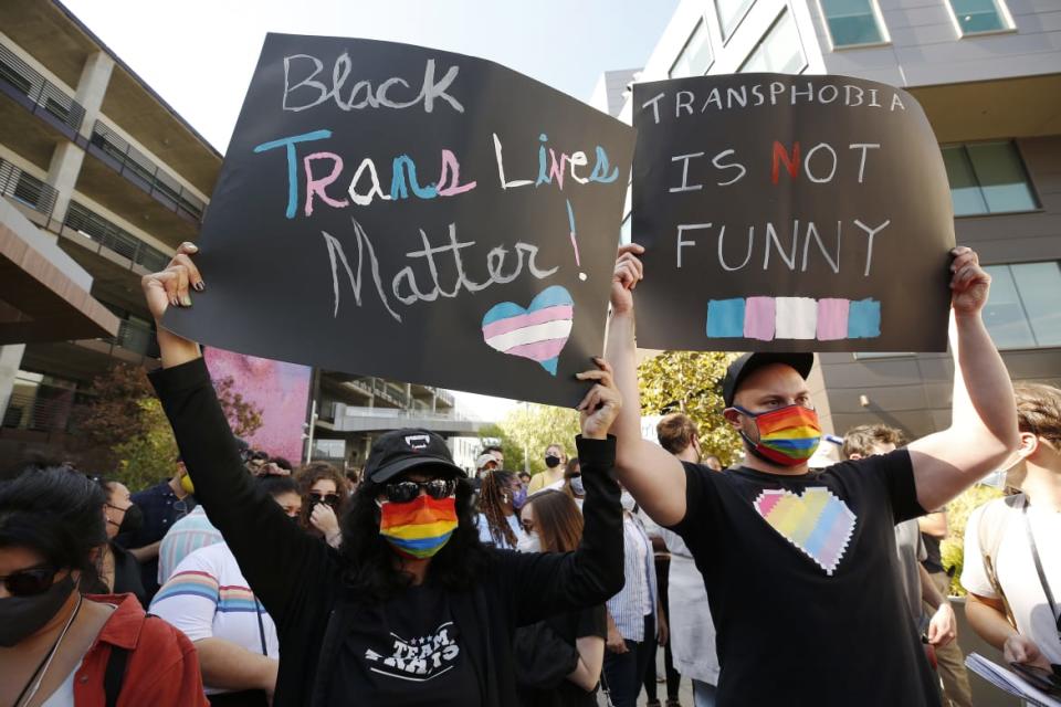 <div class="inline-image__caption"> <p>Netflix employees hold signs outside a Netflix location in Hollywood on Oct. 20, 2021, as members of the Netflix employee resource group Trans*, co-workers, and other allies staged a walkout to protest Netflix’s decision to release Dave Chappelle’s latest Netflix special, which contains a litany of transphobic material.</p> </div> <div class="inline-image__credit"> Al Seib/Getty </div>