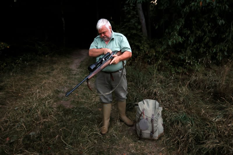 Hunter Charles-Henri de Luze checks his riffle in a field in Essertines-sur-Rolle