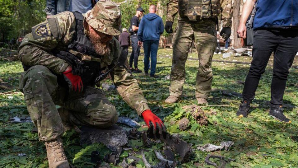   A military expert examines a bomb's fragments collected at the site of a Russian aerial bombing in the Shevchenkivskyi district on May 5, 2024 in Kharkiv, Ukraine