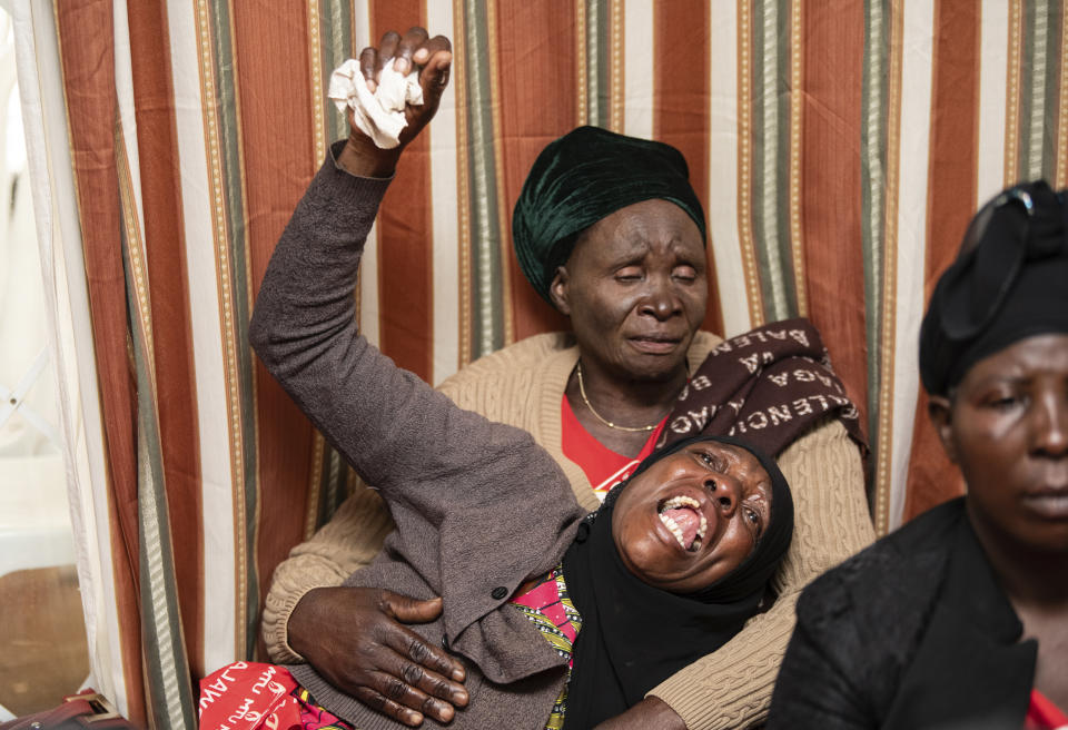 A mourner is comforted in Lilongwe, Malawi, Wednesday, June 12, 2024, following the death of Malawi's Vice President, Saulos Chilima, in a plane crash Monday. The Malawi government says that Chilima will be honored with a state funeral after he was killed along with eight other people in a plane crash. (AP Photo/Thoko Chikondi)