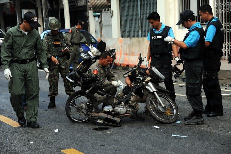 Members of a Thai bomb squad inspect the site of a motorcycle bomb blast triggered by suspected separatist militants in front of a market in the restive southern province of Narathiwat, on March 1, 2013. The blast wounded six people including a soldier, a day after Thailand signed its first known peace talk deal agreement with a rebel group in its Muslim-majority south