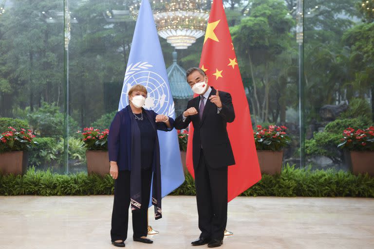 En esta imagen, distribuida por la agencia noticiosa Xinhua, el ministro de Exteriores de China, Wang Yi (derecha), saluda a la alta comisionada de la ONU para los derechos humanos, Michelle Bachelet, en Guangzhou, en la provincia de Guangdong, en el sur de China, el 23 de mayo de 2022. (Deng Hua/Xinhua vía AP)