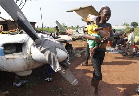 A woman walks while holding a baby at a camp in Bangui December 12, 2013.REUTERS/Emmanuel Braun