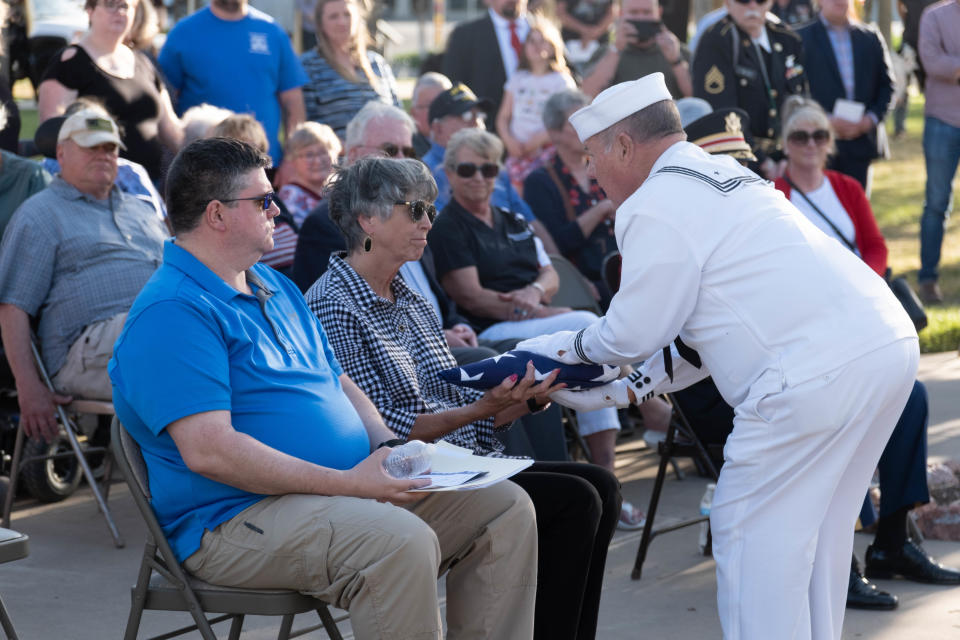 A flag honoring the three unclaimed veterans is presented to Potter County Judge Nancy Tanner Wednesday evening during the Missing in America's Project ceremony at the Texas Panhandle War Memorial Center in Amarillo.