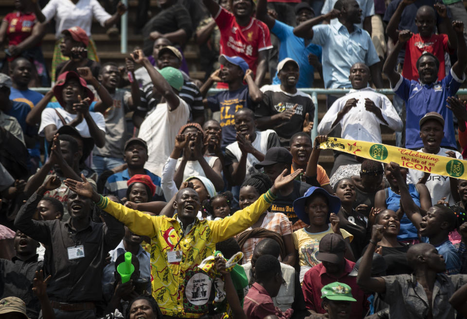 People in the stands sings songs as members of the public queue up to view the body of former president Robert Mugabe, at the Rufaro stadium in the capital Harare, Zimbabwe Friday, Sept. 13, 2019. The ongoing uncertainty of the burial of Mugabe, who died last week in Singapore at the age of 95, has eclipsed the elaborate plans for Zimbabweans to pay their respects to the former guerrilla leader at several historic sites. (AP Photo/Ben Curtis)