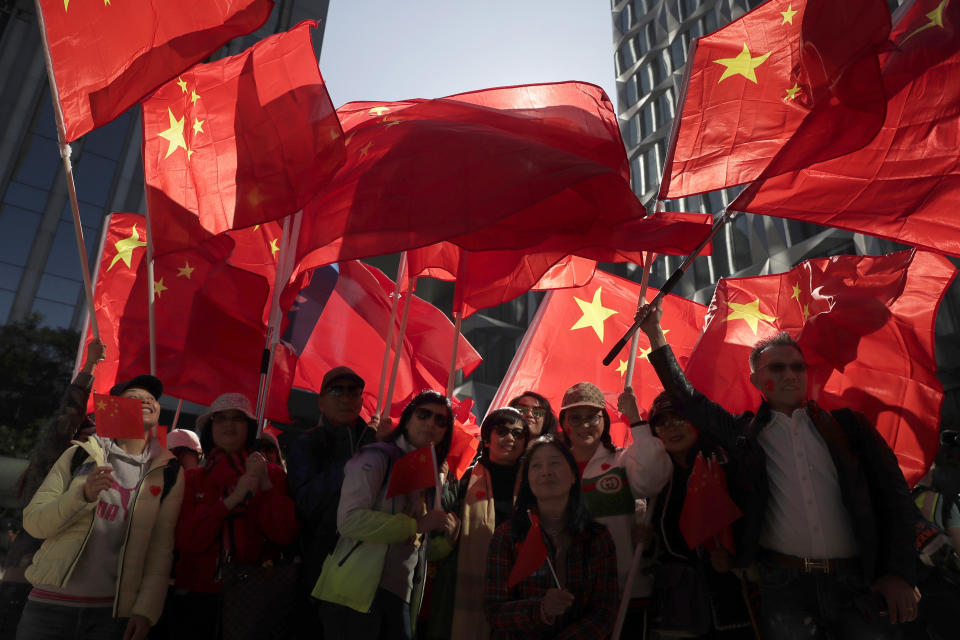 Pro-Beijing supporters wave the Chinese national flags during a rally in Hong Kong on Saturday, Dec. 7, 2019. Six months of unrest have tipped Hong Kong's already weak economy into recession. (AP Photo/Mark Schiefelbein)