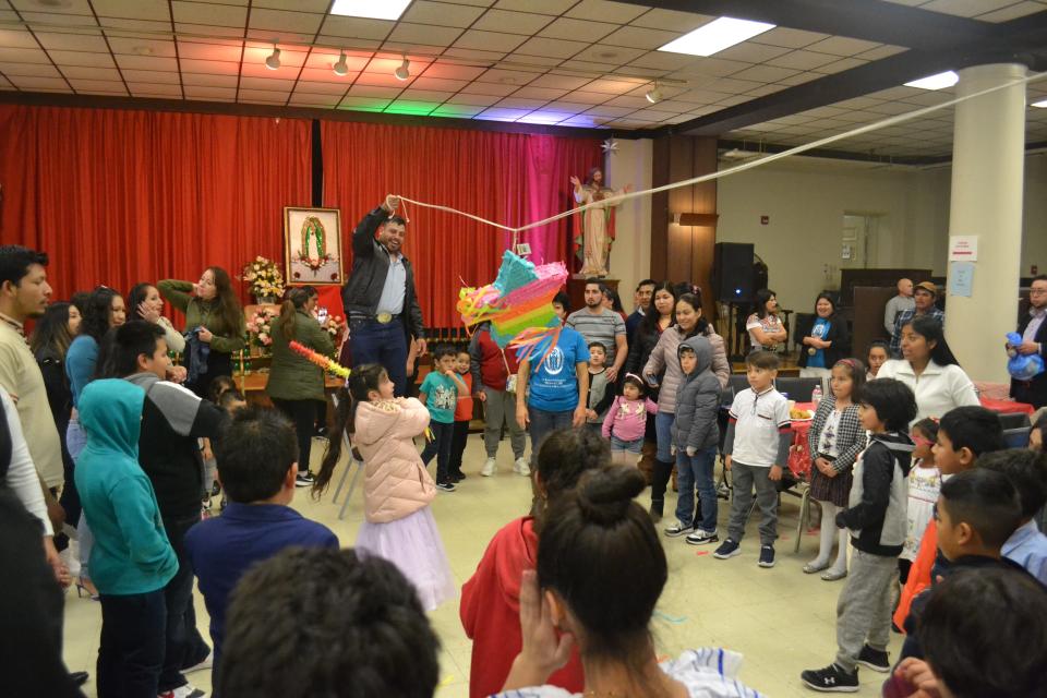 After a mass and a meal, children at the Feast Day of Our Lady of Guadalupe at St. Joseph's Church in Newport took turns swinging at a piñata filled with candy.