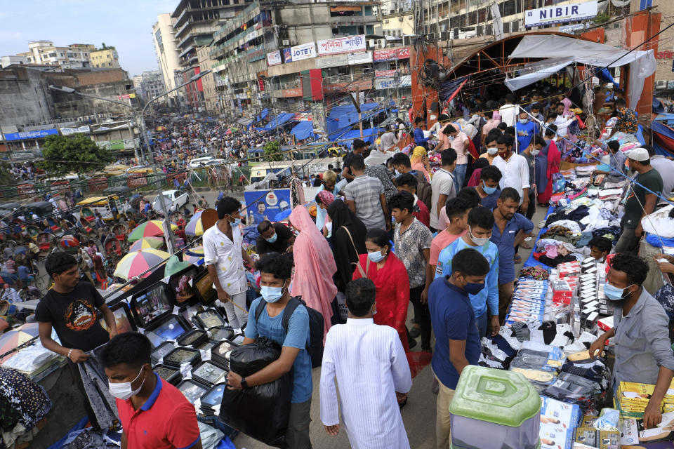 FILE - People shop at a market ahead of Eid-al Adha in Dhaka, Bangladesh, Friday, July 16, 2021. Bangladesh's economic miracle is under severe strain as fuel price hikes amplify public frustrations over rising costs for food and other necessities. (AP Photo/Mahmud Hossain Opu, File)