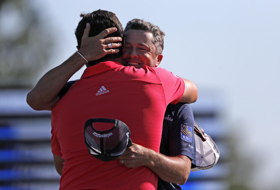 Ryan Palmer, right, hugs teammate Jon Rahm as they win the PGA Zurich Classic golf tournament at TPC Louisiana in Avondale, La., Sunday, April 28, 2019. (AP Photo/Gerald Herbert)