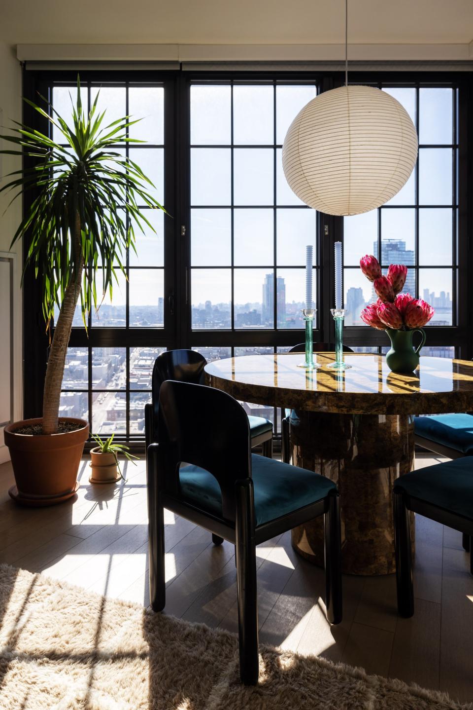 Dining room with statement vintage furniture and wall of windows