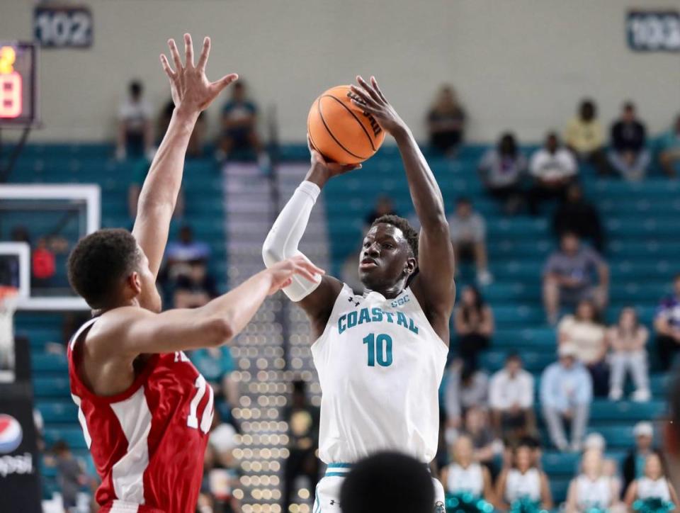 Coastal Carolina guard Ebrima Dibba shoots in front of Fresno State 7-foot NBA prospect Orlando Robinson on Friday night in the championship game of The Basketball Classic at the HTC Center in Conway, SC.