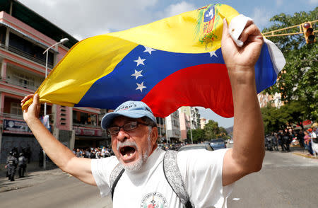 A man waves a Venezuelan flag as he takes part in a rally against Venezuelan President Nicolas Maduro's government in Caracas, Venezuela March 9, 2019. REUTERS/Carlos Garcia Rawlins