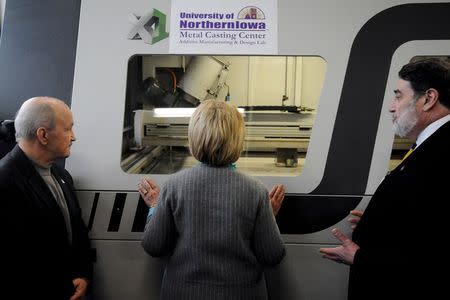 U.S. Democratic presidential candidate Hillary Clinton (C) looks through the window of a 3-D printer at Cedar Valley TechWorks in Waterloo, Iowa December 9, 2015. REUTERS/Mark Kauzlarich