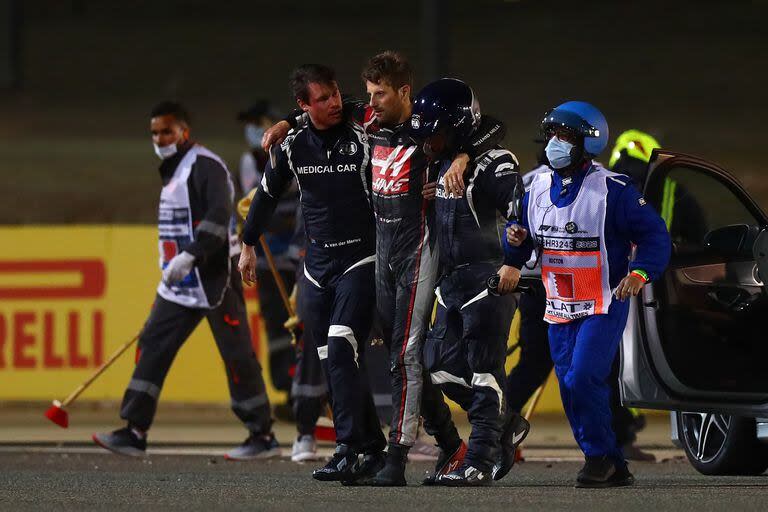 Con las manos quemadas por el fuego, Grosjean es asistido rumbo a un auto médico de Fórmula 1 luego de su accidente en el Gran Premio de Bahréin de 2020.