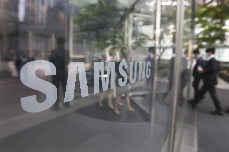 FILE - In this April 28, 2021, file photo, Employees walk past a logo of the Samsung Electronics Co. at its office in Seoul, South Korea, Wednesday, April 28, 2021. South Korea will release billionaire Lee on parole this week after he spent 18 months in prison for his role in a massive corruption scandal that triggered nationwide protests and ousted the country’s previous president. (AP Photo/Ahn Young-joon, File)