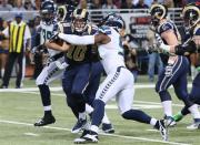 Oct 28, 2013; St. Louis, MO, USA; St. Louis Rams quarterback Kellen Clemens (10) rushes for a first down before being tackled by Seattle Seahawks defensive end Chris Clemons (91) during the first half at Edward Jones Dome. Mandatory Credit: Nelson Chenault-USA TODAY Sports