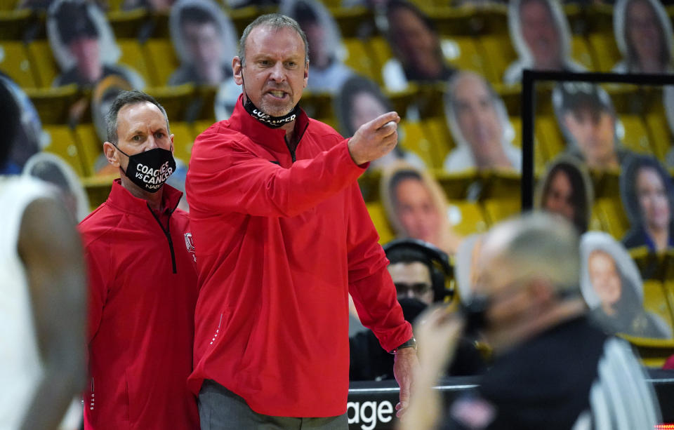 Utah head coach Larry Krystkowiak, back, argues with referees in the second half of an NCAA college basketball game against Colorado, Saturday, Jan. 30, 2021, in Boulder, Colo. (AP Photo/David Zalubowski)