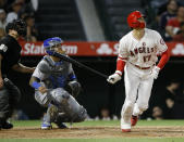 Los Angeles Angels' Shohei Ohtani, right, flies out to center field, while Kansas City Royals catcher Martin Maldonado, center, and home plate umpire Chris Guccione watch during the third inning of a baseball game in Anaheim, Calif., Saturday, May 18, 2019. (AP Photo/Alex Gallardo)