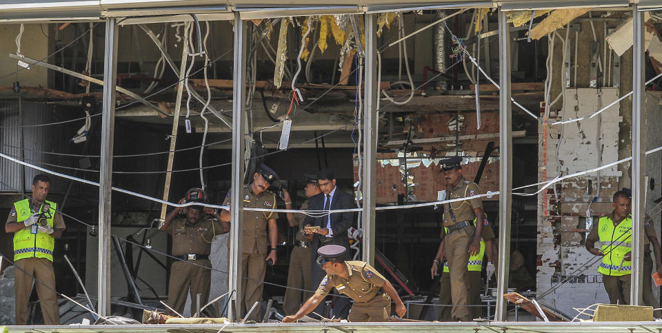 FILE - In this Sunday April 21, 2019, file photo, a Sri Lankan Police officer inspects a blast spot at the Shangri-la hotel in Colombo, Sri Lanka. Roughly 250 people died in six coordinated suicide bombings that ripped through Sri Lanka on Easter Sunday. (AP Photo/Chamila Karunarathne, file)