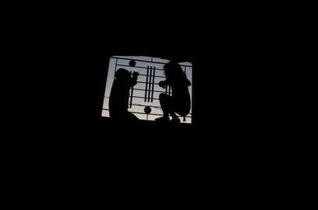 Palestinian children look out of the window of their family house during a power cut in Khan Younis, in the southern Gaza Strip, July 3, 2017. REUTERS/Mohammed Salem/Files