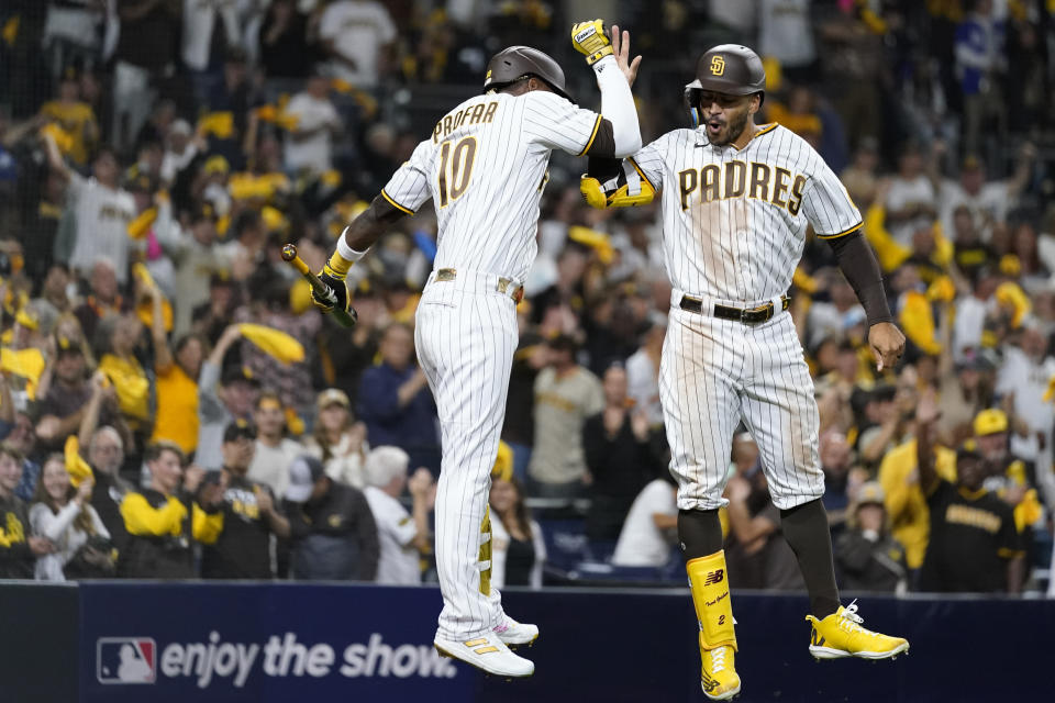 Trent Grisham (derecha), de los Padres de San Diego, festeja con su compañero Jurickson Profar tras conectar un jonrón en el tercer juego de la serie divisional ante los Dodgers de Los Ángeles, el viernes 14 de octubre de 2022 (AP Foto/Ashley Landis)