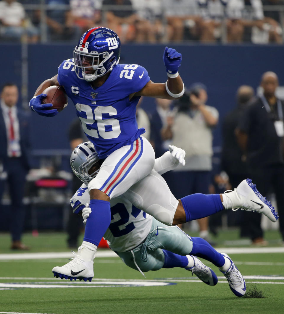 New York Giants running back Saquon Barkley (26) attempts to escape the tackle by Dallas Cowboys cornerback Chidobe Awuzie (24) in the first half of a NFL football game in Arlington, Texas, Sunday, Sept. 8, 2019. (AP Photo/Michael Ainsworth)