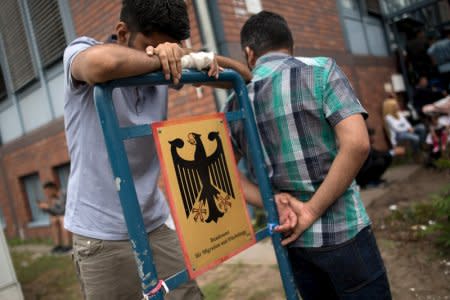 FILE PHOTO: Asylum seekers wait in front of the Federal Office for Migration and Refugees (BAMF) at Berlin's Spandau district, Germany August 17, 2015. REUTERS/Stefanie Loos/File Photo