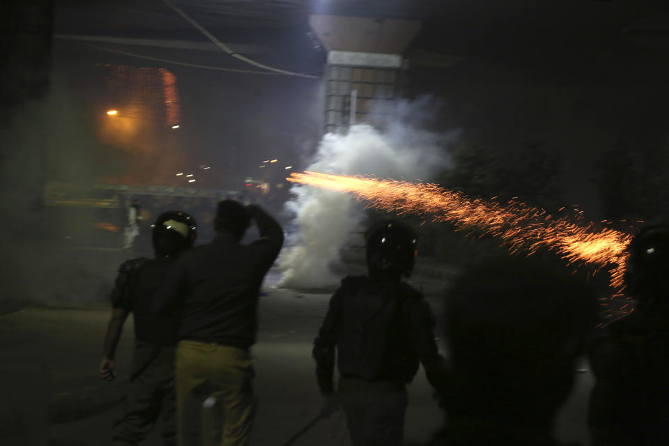 Police officers fire tear gas shell to disperse the supporters of Tehreek-e-Labiak Pakistan, a radical Islamist political party, marching toward Islamabad, in Lahore, Pakistan, Friday, Oct. 22, 2021. Thousands of Islamists launched their "long march" from the eastern city of Lahore toward Pakistan's capital, demanding that the government release the leader of their Saad Rizvi, who was arrested last year amid demonstrations against France over publishing caricatures of Islam's Prophet Muhammad. (AP Photo/K.M. Chaudary)